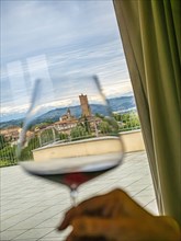 Italy, Barbaresco, Hand holding glass with barbaresco wine