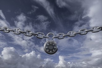 Padlock on chain against clouds