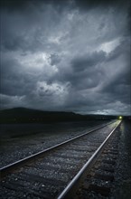 Train on railroad tracks at stormy day