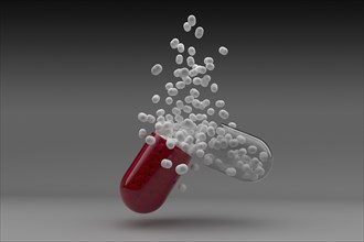Studio shot of red capsule with white pills inside