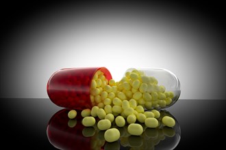 Studio shot of capsule with yellow pills inside