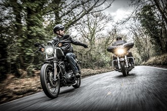 United Kingdom, London, Motorcyclists on road in forest