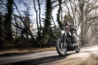 United Kingdom, London, Motorcyclist on road in forest