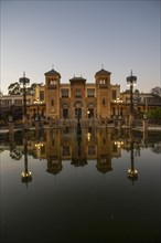 Spain, Seville, Museum of Arts and Popular Customs of Seville reflecting in pond