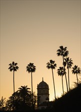 Spain, Seville, Silhouette of palm trees and tower in Maria Luisa Park
