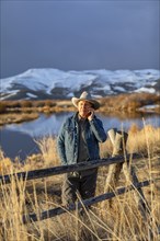 USA, Idaho, Sun Valley, Senior man in cowboy using smartphone