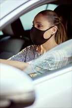 Woman with face mask driving car