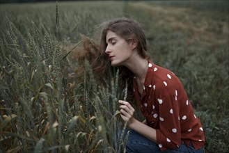 Russia, Omsk, Young women contemplating crops in field