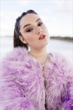 Belarus, Minsk, Outdoor portrait of young woman in pink fur coat