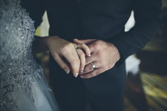 Close up of hands of bride and groom wearing wedding ring