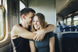 Young couple embracing in train