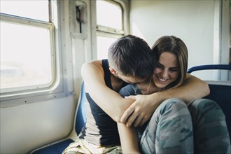 Young couple embracing in train