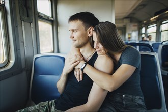 Young couple embracing in train
