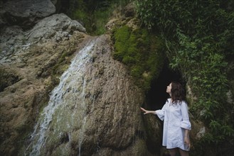 Ukraine, Crimea, Young woman standing by waterfall
