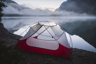 Austria, Plansee, Tent by lake Plansee at sunrise in fog