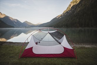 Austria, Plansee, Tent by lake Plansee in Austrian Alps at sunrise