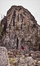 Peru, Machu Pichu, Man sitting in front of rock formation