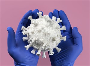 Hands in blue latex gloves holding Coronavirus model