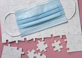 Surgical mask on white jigsaw puzzle