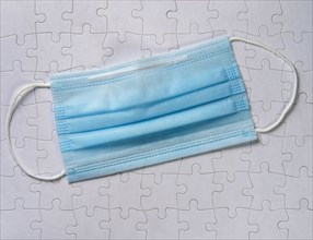 Surgical mask on white jigsaw puzzle