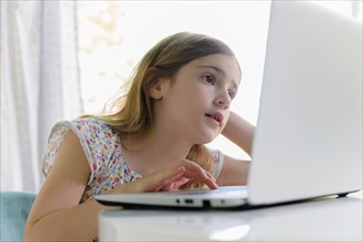 Girl (6-7) using laptop during remote learning