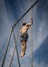 Man exercising on rope