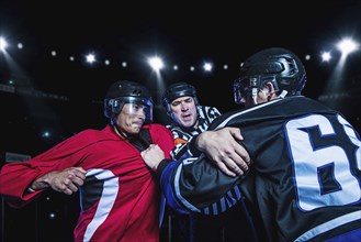 Referee separating fighting hockey players