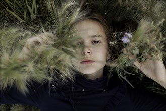 Russia, Omsk, Portrait of girl (12-13) in foliage