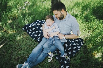 Father with son (2-3) on picnic blanket