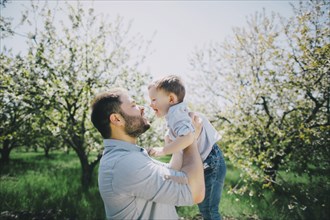 Father with son (2-3) in orchard