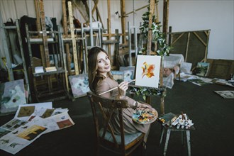 Woman painting on canvas in art studio