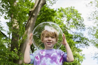 Boy wearing bubble outdoors to socially distance
