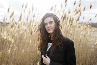 Russia, Omsk, Portrait of young woman in tall grass