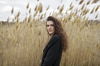 Russia, Omsk, Portrait of young woman in tall grass