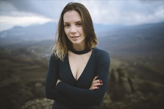 Ukraine, Crimea, Portrait of young woman with mountain valley in background