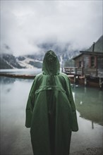 Italy, Man in raincoat standing Pragser Wildsee,