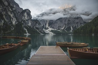 Italy, Wooden boats moored by pier at Pragser Wildsee in Dolomites,
