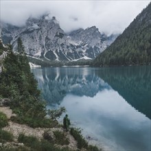 Italy, Mountains reflecting in Pragser Wildsee in Dolomites,