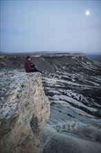 Ukraine, Crimea, Hiker sitting on edge of steep cliff near White Mountain