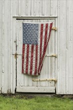 American flag hanging on barn door,,