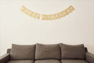Happy birthday wishes on wall above sofa,,