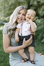 Outdoor portrait of smiling mother with baby son