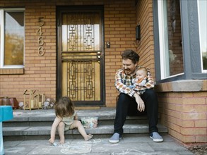 Father with kids sitting on porch