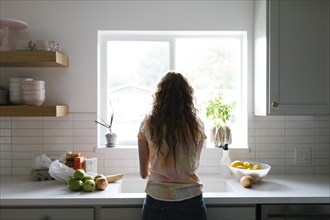 Woman washing fruit and vegetables in kitchen