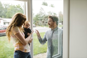 Father visiting partner and son (6-11 months) through window