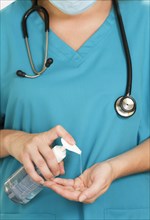 Female hospital worker using hand sanitizer