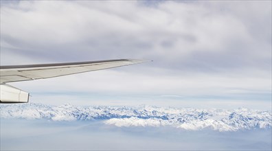 Switzerland, Canton Wallis, Airplane wing over snowy mountains