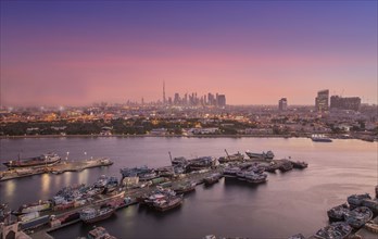 United Arab Emirates, Dubai, Boats on Dubai Creek and skyline at sunset