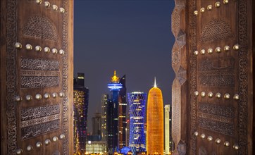 Qatar, Doha, Modern buildings seen through old door