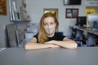 Portrait of woman wearing flu mask in office